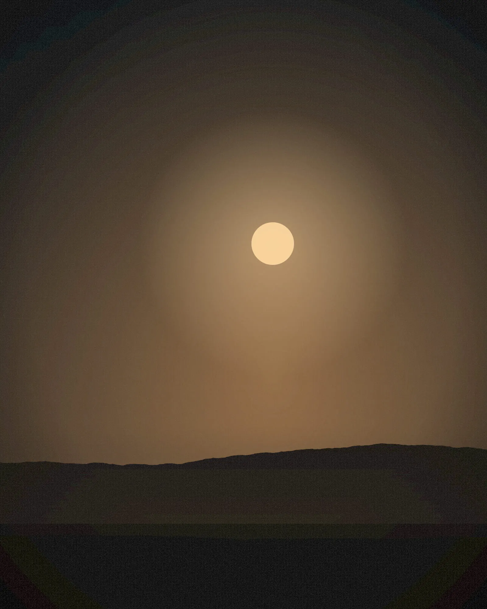 A lamplit window glowing through evening haze.